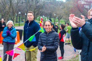 Des Linden smiling and clapping at the race finish line.