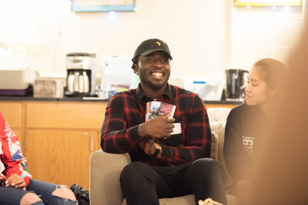 Nana Kwame Adjei-Brenyah smiling, holding an 826 Boston book.