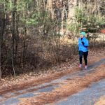 Ale runs along a tree-covered road while training to run the 2020 Boston Marathon© for 826 Boston.