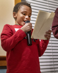 826 Boston student Isaa reads his script during the book release party of “When the Lights Go Out.”