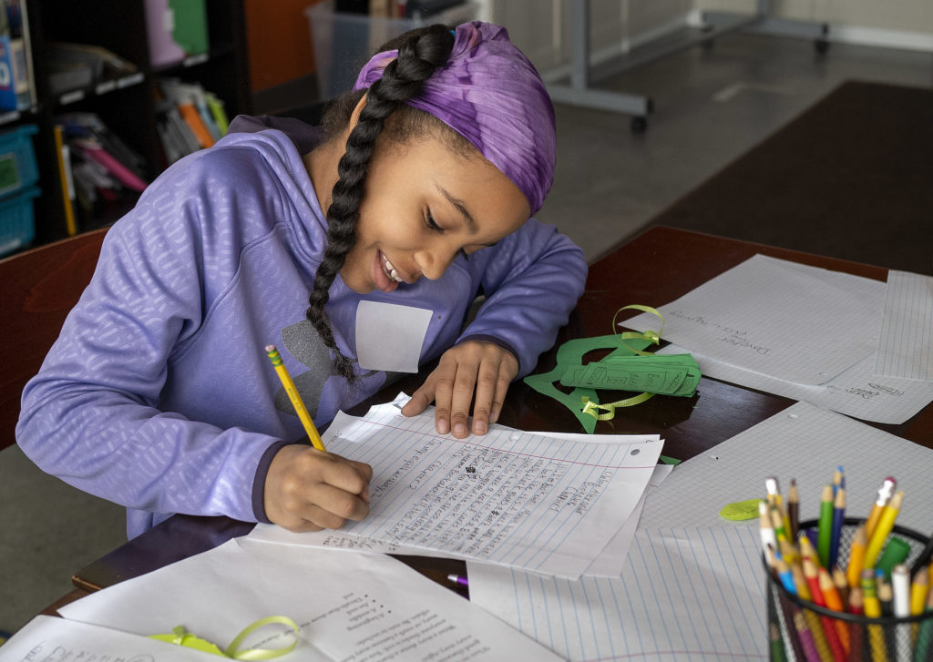A student writes a story during a February break workshop.