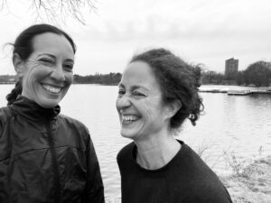 A black and white photo shows Kristin (left) and Jody (right) smiling and laughing together.
