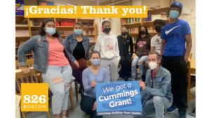Students and volunteers at New Mission High School—one of the schools served by 826 Boston as part of the Cummings grant—hold a sign that says "We got a Cummings Grant"