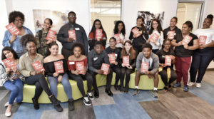 A group of 826 Boston students hold up the new book they were published in.